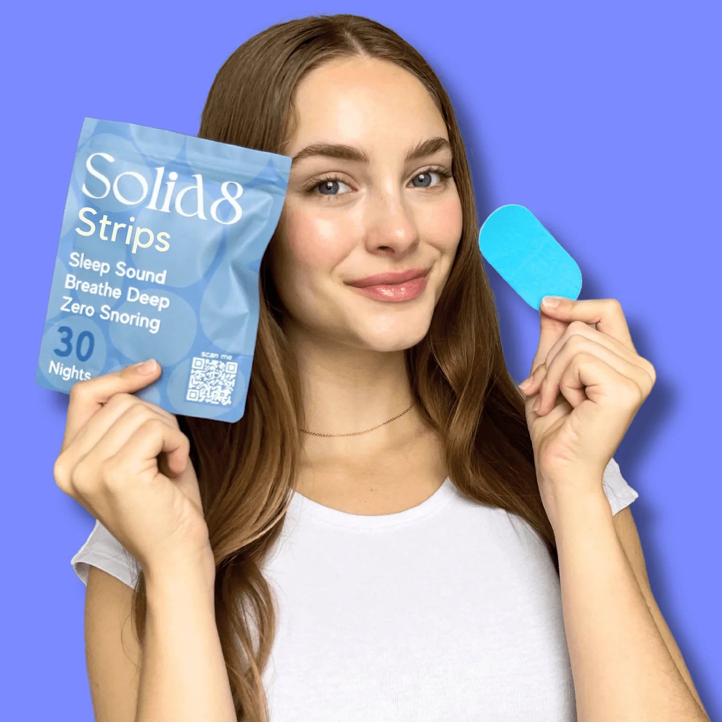 Woman holding Solid8 Mouth Tape pack and a single blue strip from the 360 hypoallergenic tapes yearly subscription for better sleep and snoring relief.