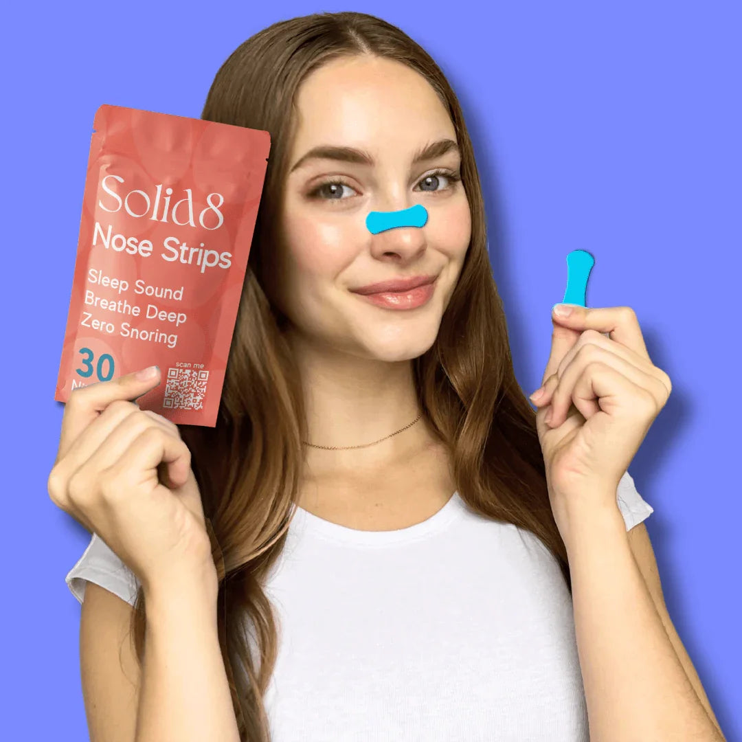 Woman applying Solid8 Nose Strip with Triple Band Lift, holding pack and strip to promote snoring relief and improved sleep quality.